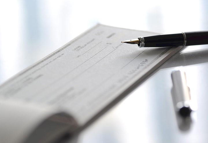 Image of a checkbook and pen on a desktop