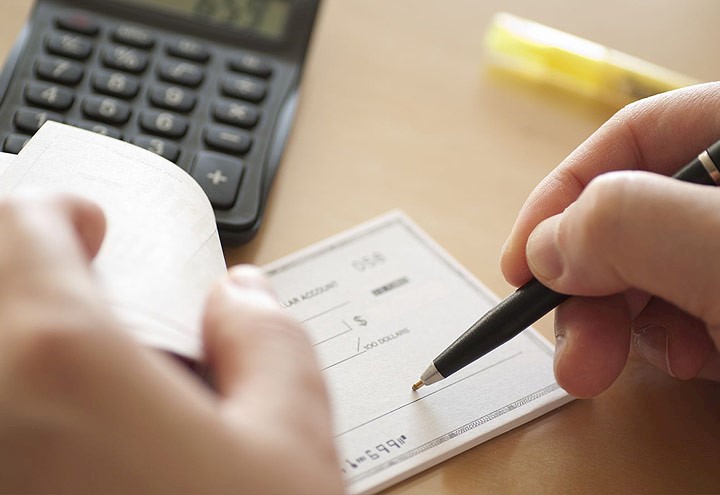 Image of person writing a check